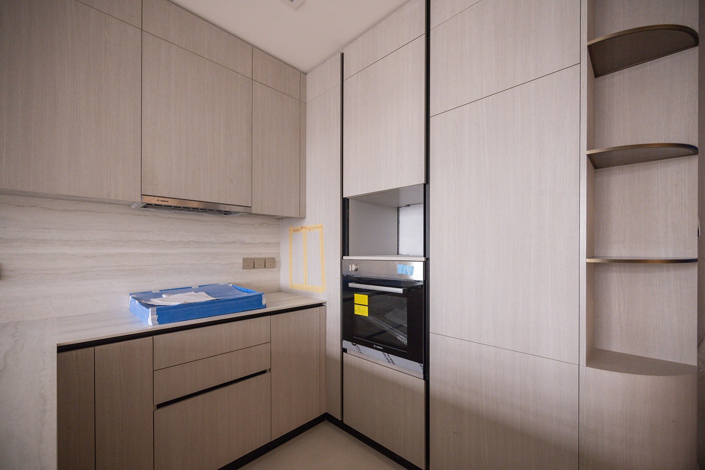 Pearl House By Imtiaz Modern kitchen featuring light wood cabinetry, a sleek countertop, and an integrated oven. Minimalist design elements.